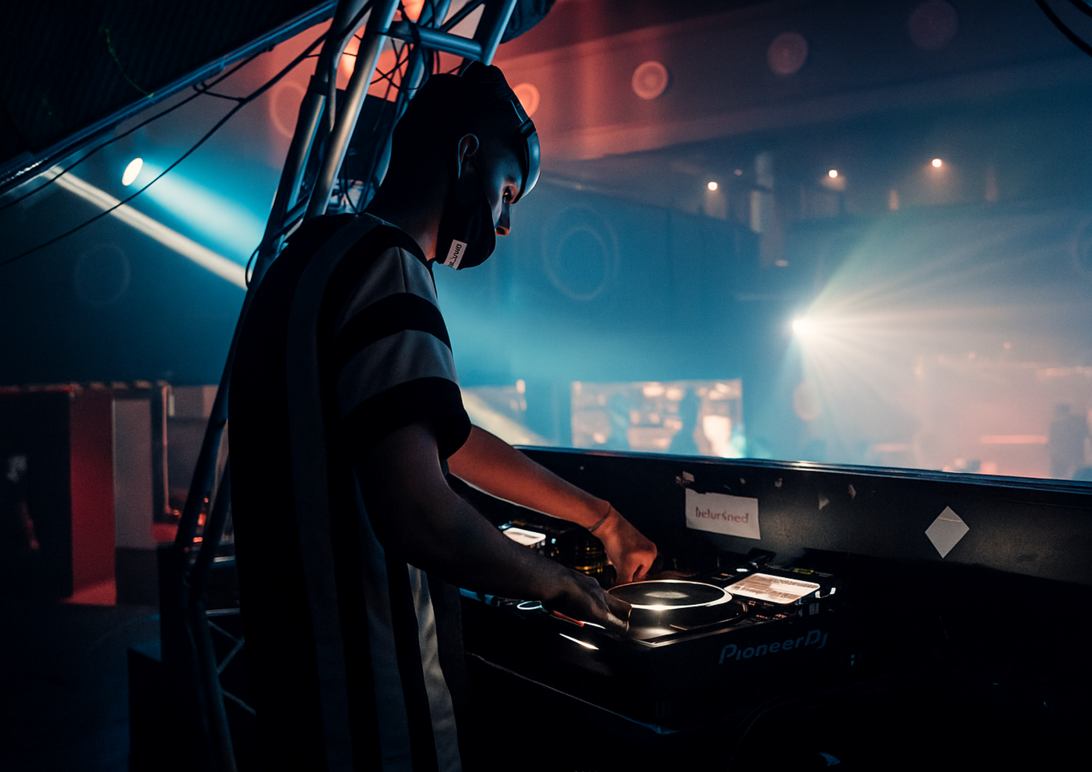 DJ Tali at the turntables with dramatic club lighting